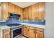 Updated kitchen with wooden cabinets, sleek countertops, and stainless steel oven and microwave at 3224 Troy St, Aurora, CO 80011