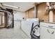 Functional laundry room features washer, dryer, water heater, and convenient utility sink for added convenience at 3224 Troy St, Aurora, CO 80011
