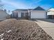 Charming blue home featuring a well-manicured rock front yard and attached two car garage at 3125 S Gibralter St, Aurora, CO 80013