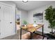 Bright home office features a wood desk, leafy plants, and view into living area at 30 S Yates St, Denver, CO 80219