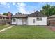 Rear view of charming ranch house with freshly painted exterior and yard at 30 S Yates St, Denver, CO 80219