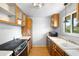 Functional kitchen with wood cabinets, a vintage sink, and a window overlooking the side yard at 3341 W 94Th Ave, Westminster, CO 80031