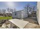 Backyard featuring a detached garage, green grass, and a concrete patio with a dining set at 4354 Chase St, Denver, CO 80212