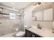 Bathroom with tiled shower, modern vanity, and ample lighting at 4354 Chase St, Denver, CO 80212