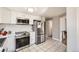 Modern kitchen features white cabinets, stainless appliances, and tiled floors at 4354 Chase St, Denver, CO 80212
