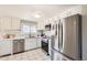 Bright kitchen with white cabinets, stainless steel appliances, and tile flooring at 4354 Chase St, Denver, CO 80212
