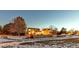 Home's backyard, illuminated at night, with a wooden fence and snowy ground at 13363 Cherry Ct, Thornton, CO 80241