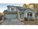 Two-story teal home with solar panels and attached garage at 13363 Cherry Ct, Thornton, CO 80241