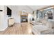 Living room with a fireplace, L-shaped sofa, and wood-look flooring at 13363 Cherry Ct, Thornton, CO 80241