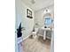 Powder room with pedestal sink, decorative fixtures, and wood floors at 12566 Dexter St, Thornton, CO 80241
