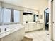 Bright bathroom features a soaking tub, double vanity, and neutral tile floors at 12566 Dexter St, Thornton, CO 80241