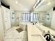 Well-lit bathroom with double vanity, shower, and soaking tub at 12566 Dexter St, Thornton, CO 80241