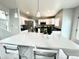 Modern kitchen featuring a spacious island with bar seating, white cabinetry, and stainless-steel appliances at 12566 Dexter St, Thornton, CO 80241