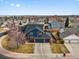 Aerial view of a blue home with a three-car garage, surrounded by neighborhood homes, showcasing location at 8346 Vivian St, Arvada, CO 80005