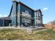 Two-story home with blue siding and a backyard featuring a patio, grill, and seating, perfect for entertaining at 8346 Vivian St, Arvada, CO 80005