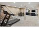Finished basement area featuring a treadmill, dining set, and sectional sofa at 8346 Vivian St, Arvada, CO 80005