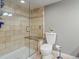 Tiled walk-in shower with a glass door, plus a toilet with neutral wall paint creating a calming space at 8346 Vivian St, Arvada, CO 80005