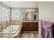 Bathroom featuring bathtub, walk-in shower, and double vanity at 8346 Vivian St, Arvada, CO 80005