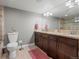Bathroom featuring dark wood cabinets, granite countertop, and a large mirror creating an elegant space at 8346 Vivian St, Arvada, CO 80005