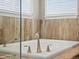 Close up of bathtub featuring elegant fixtures and tile surround at 8346 Vivian St, Arvada, CO 80005