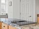 Kitchen detail showcasing granite countertops and a sleek, built-in cooktop at 8346 Vivian St, Arvada, CO 80005
