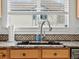 A kitchen sink area featuring granite countertops and a modern faucet at 8346 Vivian St, Arvada, CO 80005