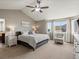 Bright main bedroom featuring a ceiling fan, chair, and large windows at 8346 Vivian St, Arvada, CO 80005