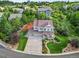 Aerial view of a beautiful two-story home with a three car garage surrounded by lush landscaping and mature trees at 2384 Crestridge Dr, Castle Rock, CO 80104