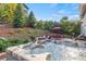 Beautiful backyard includes a hot tub with an umbrella-covered outdoor seating area and mature landscaping at 2384 Crestridge Dr, Castle Rock, CO 80104