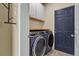 Convenient laundry room featuring a modern washer and dryer, cabinetry, and a stylish patterned floor at 2384 Crestridge Dr, Castle Rock, CO 80104