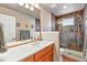 Bathroom featuring vanity with a large mirror and a tile surround shower at 6776 Salvia Ct, Arvada, CO 80007