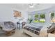 Bright bedroom featuring light blue walls, a chair, a bed, and a large window for natural light at 6776 Salvia Ct, Arvada, CO 80007