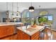 Open kitchen and dining area with large windows, island seating, and outdoor views at 6776 Salvia Ct, Arvada, CO 80007