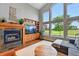 Cozy living room features a fireplace and large windows overlooking the lush golf course at 6776 Salvia Ct, Arvada, CO 80007