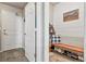 Inviting mudroom boasts a wood bench with shoe storage, planked walls, and access to the home's front door at 6776 Salvia Ct, Arvada, CO 80007