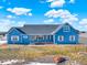 Ranch style home with blue siding, three car garage and covered porch at 767 S Main St, Byers, CO 80103