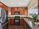 Kitchen with dark wood cabinets, granite counters, and stainless steel appliances at 767 S Main St, Byers, CO 80103