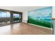 Bright living room featuring mountain-themed mural on the wall and large sliding doors to balcony at 1155 N Ash St # 1206, Denver, CO 80220