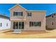 Rear exterior of tan two-story home with dark shutters and sliding glass doors to the backyard at 459 S Salida St, Aurora, CO 80017