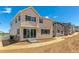 Rear exterior of tan two-story home with dark shutters and sliding glass doors to the backyard at 459 S Salida St, Aurora, CO 80017