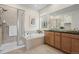 A well-lit bathroom has a glass-enclosed shower, a separate soaking tub, and a double vanity at 836 Sundance Ln, Erie, CO 80516
