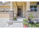 Inviting front porch featuring stone accents, flower pots, and a sheltered entryway at 836 Sundance Ln, Erie, CO 80516