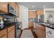 Modern kitchen featuring stainless steel appliances, granite countertops, and wooden cabinets at 836 Sundance Ln, Erie, CO 80516