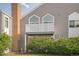 Two-story townhouse featuring brick chimneys, stylish windows, and a balcony above lush landscaping at 3331 S Monaco Pkwy # D, Denver, CO 80222