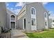 Gray two-story townhouse featuring stylish windows, green lawn, and a welcoming entrance at 3331 S Monaco Pkwy # D, Denver, CO 80222