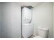 Functional laundry closet featuring a stacked washer and dryer unit and an adjacent toilet at 3331 S Monaco Pkwy # D, Denver, CO 80222