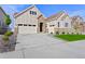 Two-story house with stone and beige siding, a three-car garage, and a landscaped lawn at 7033 S Waterloo Way, Aurora, CO 80016