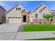 Two-story house with stone and beige siding, a three-car garage, and a landscaped lawn at 7033 S Waterloo Way, Aurora, CO 80016