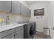 Bright laundry room with washer, dryer, and cabinets at 7033 S Waterloo Way, Aurora, CO 80016