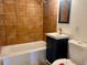 Bathroom with brown tile, single vanity, and bathtub at 14141 E Jewell Ave # 102, Aurora, CO 80012